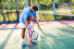 Famille jouant le tennis sur la cour extérieure photos stock Famille jouant le tennis sur la cour extérieure photos stock