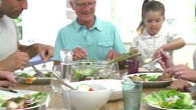 Famille multi de génération mangeant le repas autour de la table de cuisine banque de vidéos Famille multi de génération mangeant le repas autour de la table de cuisine banque de vidéos