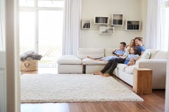 Famille s'asseyant sur Sofa At Home Watching TV ensemble photo libre de droits Famille s'asseyant sur Sofa At Home Watching TV ensemble photo libre de droits