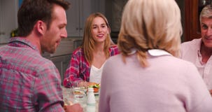 Family With Adult Offspring Enjoying Meal At Home Together