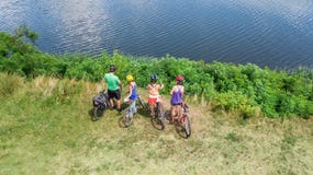 Family on bikes cycling outdoors, active parents and kids on bicycles, aerial view of happy family with children relaxing stock photography Family on bikes cycling outdoors, active parents and kids on bicycles, aerial view of happy family with children relaxing stock photography