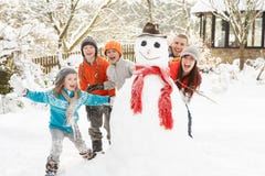 Family Building Snowman In Garden Royalty Free Stock Photography