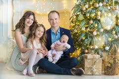 Family on Christmas eve at fireplace. Kids opening Xmas presents. Children under Christmas tree with gift boxes. Decorated living stock image Family on Christmas eve at fireplace. Kids opening Xmas presents. Children under Christmas tree with gift boxes. Decorated living stock image