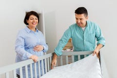 Family couple arranging baby bed with mattress stock photography Family couple arranging baby bed with mattress stock photography