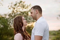 Family couple in a forest park at sunset look eye to eye stock photo Family couple in a forest park at sunset look eye to eye stock photo