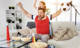 Family of fans watching a football match on TV at home Stock Photo Family of fans watching a football match on TV at home Stock Photo