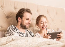 Family having fun while using tablet in a bed Stock Image Family having fun while using tablet in a bed Stock Image