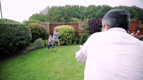 Family Having a Water Fight in the Garden