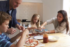Family At Home In Kitchen Making Pizzas Together royalty free stock photos Family At Home In Kitchen Making Pizzas Together royalty free stock photos