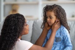 Family Misunderstanding, Childhood Problems. Young Black Mother Comforting Her Sad Offended Daughter At Home Royalty Free Stock Photos