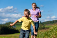 Family outdoors is running on a meadow Royalty Free Stock Photography Family outdoors is running on a meadow Royalty Free Stock Photography