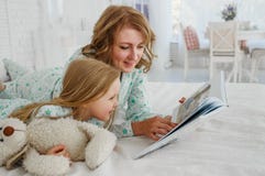 Family reading bedtime. Pretty young mother reading a book to her daughter. Mother reads a fairy tale to her daughter. A royalty free stock photos Family reading bedtime. Pretty young mother reading a book to her daughter. Mother reads a fairy tale to her daughter. A royalty free stock photos