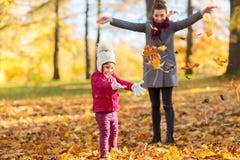 Happy family playing with autumn leaves at park Stock Images Happy family playing with autumn leaves at park Stock Images