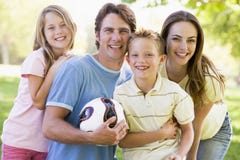 Family standing holding volleyball smiling
