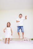 Family Values And Relationships. Happy Kids Playing Indoors. Jumping On The Bed Together. Royalty Free Stock Photography