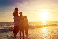 family watching the sunset on the beach