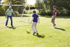 Família da geração do homem três que joga o futebol junto imagem de stock Família da geração do homem três que joga o futebol junto imagem de stock