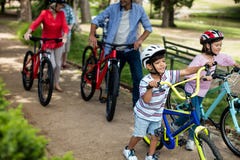 família da Multi-geração que anda com a bicicleta no parque fotografia de stock família da Multi-geração que anda com a bicicleta no parque fotografia de stock