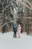 Família de passeio com uma criança A família anda na natureza no inverno Caminhada da família do inverno na natureza Muita neve fotografia de stock royalty free Família de passeio com uma criança A família anda na natureza no inverno Caminhada da família do inverno na natureza Muita neve fotografia de stock royalty free