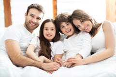 Família de sorriso na cama foto de stock Família de sorriso na cama foto de stock