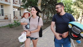 A família está andando Uma criança dá felizmente cinco a seu pai e gena então jogos com o barco inflável do ` s das crianças filme A família está andando Uma criança dá felizmente cinco a seu pai e gena então jogos com o barco inflável do ` s das crianças filme