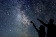 A família feliz está olhando o chuveiro de meteoro Nigh céu imagens de stock A família feliz está olhando o chuveiro de meteoro Nigh céu imagens de stock