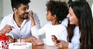Família feliz que comemora o aniversário de sua criança imagem de stock Família feliz que comemora o aniversário de sua criança imagem de stock