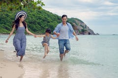 Família feliz que joga na praia no tempo do dia Fotografia de Stock Família feliz que joga na praia no tempo do dia Fotografia de Stock