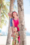 Família, geração - avó de sorriso feliz, avô e suporte pequeno perto da palma na praia imagens de stock royalty free Família, geração - avó de sorriso feliz, avô e suporte pequeno perto da palma na praia imagens de stock royalty free