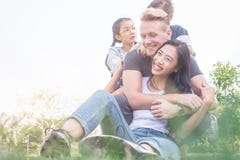 Família que relaxa no jardim Família nova com as crianças que têm o divertimento na natureza foto de stock Família que relaxa no jardim Família nova com as crianças que têm o divertimento na natureza foto de stock
