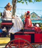 Famílias espanholas no vestido tradicional que viaja no transportes puxados a cavalo em April Fair, Sevilha Feria de Sevilla just foto de stock Famílias espanholas no vestido tradicional que viaja no transportes puxados a cavalo em April Fair, Sevilha Feria de Sevilla just foto de stock