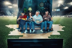 Fan de futebol do futebol que sentam-se no sofá e na tevê de observação no meio de um campo de futebol fotos de stock Fan de futebol do futebol que sentam-se no sofá e na tevê de observação no meio de um campo de futebol fotos de stock