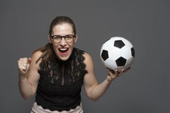 Fan de futebol entusiasmado novo da mulher que guarda a bola de futebol nas m?os foto de stock Fan de futebol entusiasmado novo da mulher que guarda a bola de futebol nas m?os foto de stock