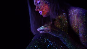 Fantastisk stående av den härliga modekvinnan med purpurfärgat hår i UV ljus för neon Modell Girl med fluorescerande idérikt stock video Fantastisk stående av den härliga modekvinnan med purpurfärgat hår i UV ljus för neon Modell Girl med fluorescerande idérikt stock video