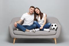Fanáticos del fútbol sonrientes del hombre de la mujer de los pares en la alegría blanca de la camiseta encima del equipo preferi imágenes de archivo libres de regalías Fanáticos del fútbol sonrientes del hombre de la mujer de los pares en la alegría blanca de la camiseta encima del equipo preferi imágenes de archivo libres de regalías