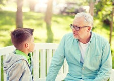 Farfadern och sonsonen som talar p? sommar, parkerar arkivfoton Farfadern och sonsonen som talar p? sommar, parkerar arkivfoton