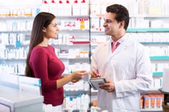 Farmacéutico experimentado que aconseja al cliente femenino imágenes de archivo libres de regalías Farmacéutico experimentado que aconseja al cliente femenino imágenes de archivo libres de regalías