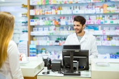 Farmacéutico experimentado que aconseja al cliente femenino en farmacia fotografía de archivo libre de regalías Farmacéutico experimentado que aconseja al cliente femenino en farmacia fotografía de archivo libre de regalías