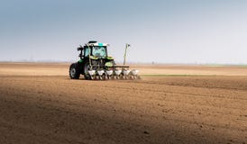 Farmer with tractor seeding sowing crops at agricultural field stock images Farmer with tractor seeding sowing crops at agricultural field stock images