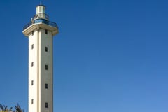 Faro al mediodía en un día claro en fondo vacío del cielo azul Papel pintado en el tema marino con un faro fotografía de archivo libre de regalías Faro al mediodía en un día claro en fondo vacío del cielo azul Papel pintado en el tema marino con un faro fotografía de archivo libre de regalías