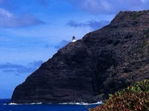 Faro che alza sopra una scogliera rocciosa che confina l'oceano Pacifico fotografia stock libera da diritti Faro che alza sopra una scogliera rocciosa che confina l'oceano Pacifico fotografia stock libera da diritti