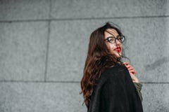 Fashion consept: beatiful young girl with long hair, glasses, red lips standing near modern wall wearing in green suit and grey je royalty free stock photo Fashion consept: beatiful young girl with long hair, glasses, red lips standing near modern wall wearing in green suit and grey je royalty free stock photo
