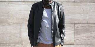 Fashion man wearing a black leather jacket in the city. On a gray background close-up Stock Images Fashion man wearing a black leather jacket in the city. On a gray background close-up Stock Images