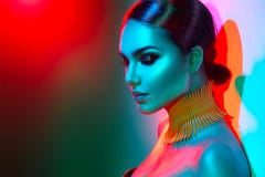Fashion model woman in colorful bright lights posing