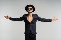 Fashion portrait of handsome elegant man in black suit and hat posing in studio stock photo Fashion portrait of handsome elegant man in black suit and hat posing in studio stock photo