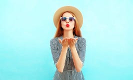 Fashion portrait woman with red lips sends an air kiss in summer hat stock image Fashion portrait woman with red lips sends an air kiss in summer hat stock image