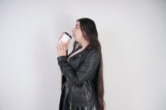 Fashionable alternative girl with a paper Cup of coffee on a white background in the Studio stock photography Fashionable alternative girl with a paper Cup of coffee on a white background in the Studio stock photography