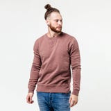Fashionable man with beard and bun hairstyle dressed in light-brown long sleeve sweater and jeans poses in the studio on royalty free stock photos Fashionable man with beard and bun hairstyle dressed in light-brown long sleeve sweater and jeans poses in the studio on royalty free stock photos