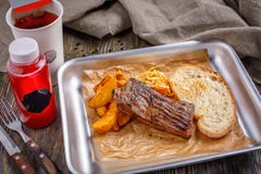 Fast food em um restaurante Um bife bem-fritado com batatas fritas friáveis douradas e almoço combinado brindado do brinde friáve fotografia de stock royalty free Fast food em um restaurante Um bife bem-fritado com batatas fritas friáveis douradas e almoço combinado brindado do brinde friáve fotografia de stock royalty free