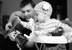 Father and baby girl playing guitar